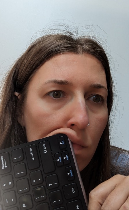 Photo of a depressed looking writer jabbing a keyboard into their mouth